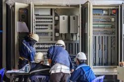 Engineers replacing legacy PLC hardware during an industrial control system migration project