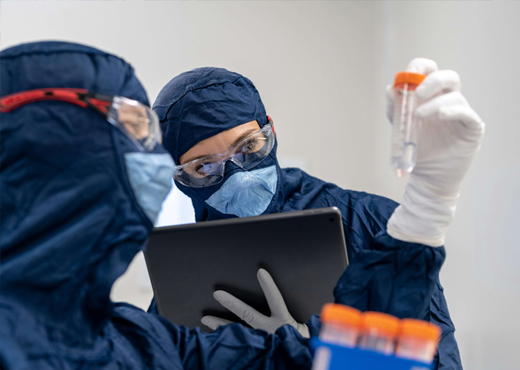 Laboratory technicians performing pharmaceutical quality control and life sciences testing in a cleanroom environment